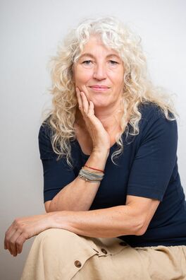 Petra Endres von Dialogwege sitzend mit blauem Shirt
